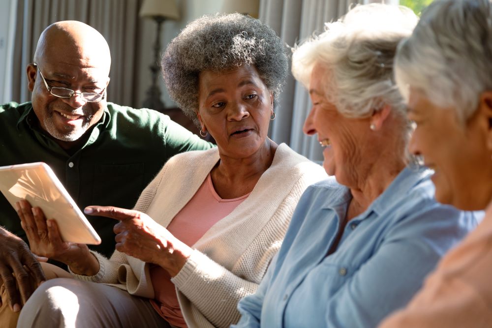 Three women and a man talking sitting on a couch